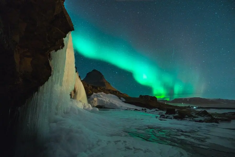 A green light is shining over the mountains.