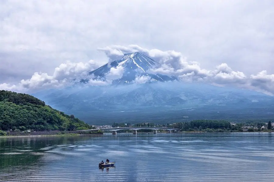 A boat is in the water near a mountain.