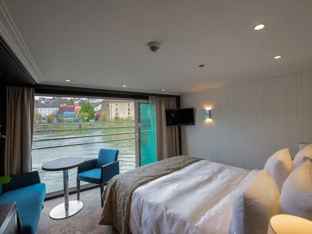 A bedroom with a bed, table and chairs.