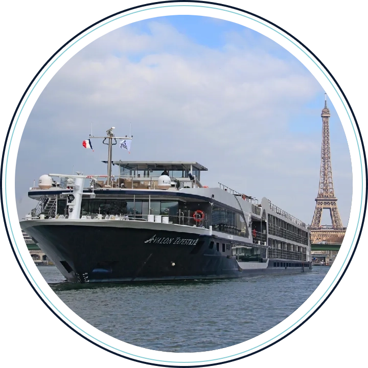 A large cruise ship in the water near a tower.