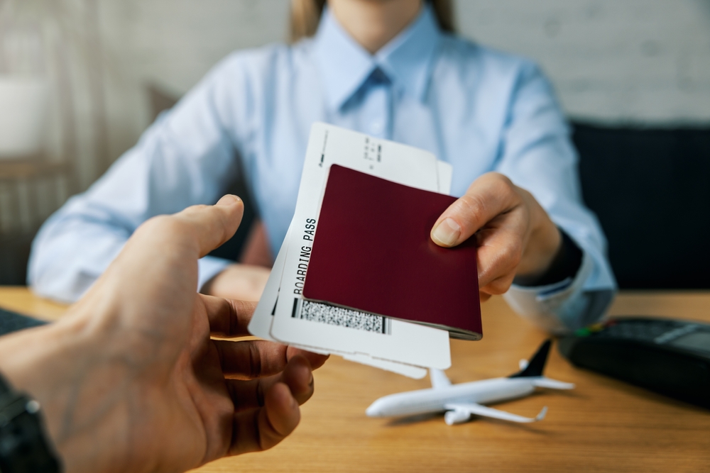 Travel,agent,give,flight,tickets,and,passport,to,customer,at